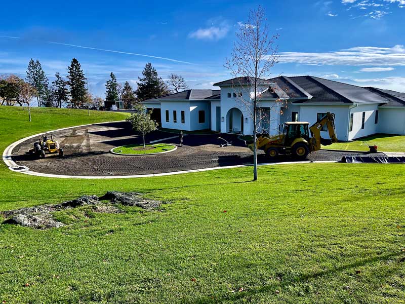 backyard area with a white house and a green turf lawn