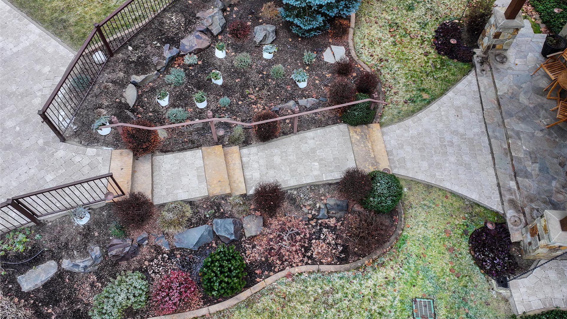 aerial view of a paver pathway with bushes and nice landscaping surrounding it