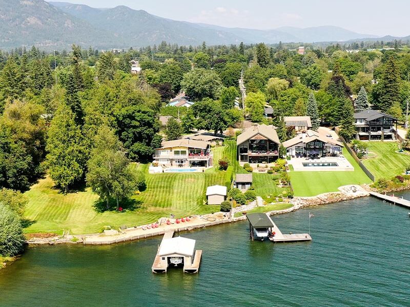 aerial view of river houses with nice lush backyards and a river with boat docks