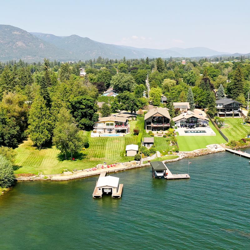 aerial view of river houses with nice lush backyards and a river with boat docks