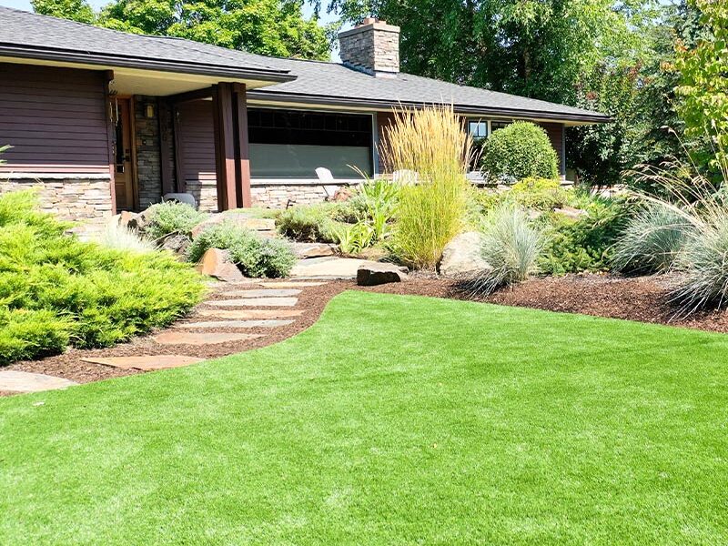 home with lush landscaping and a curvy lawn and stone pathway