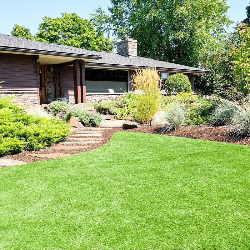 home with lush landscaping and a curvy lawn and stone pathway