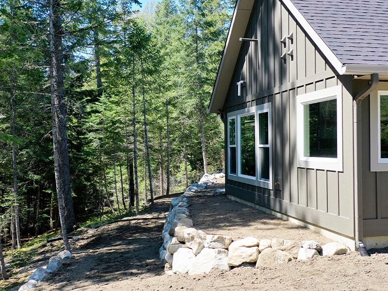 multi level lawn area prepped for grass or turf installation with forest area in the background