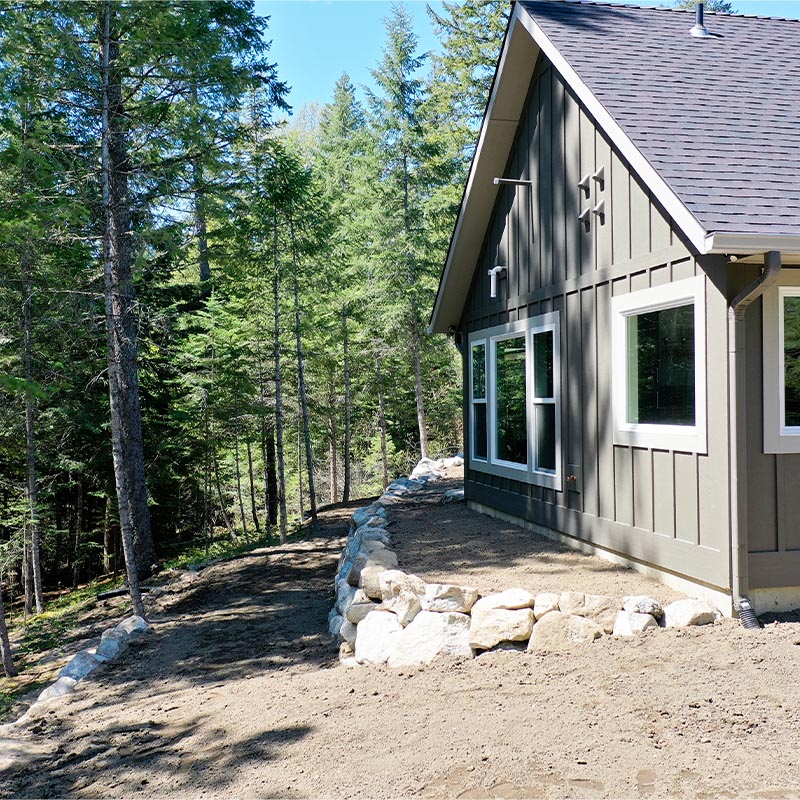 multi level lawn area prepped for grass or turf installation with forest area in the background