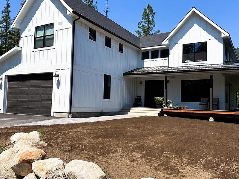 front yard area with ground prepped for lawn installation with white house in the background