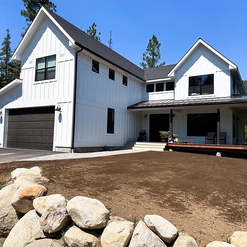 front yard area with ground prepped for lawn installation with white house in the background